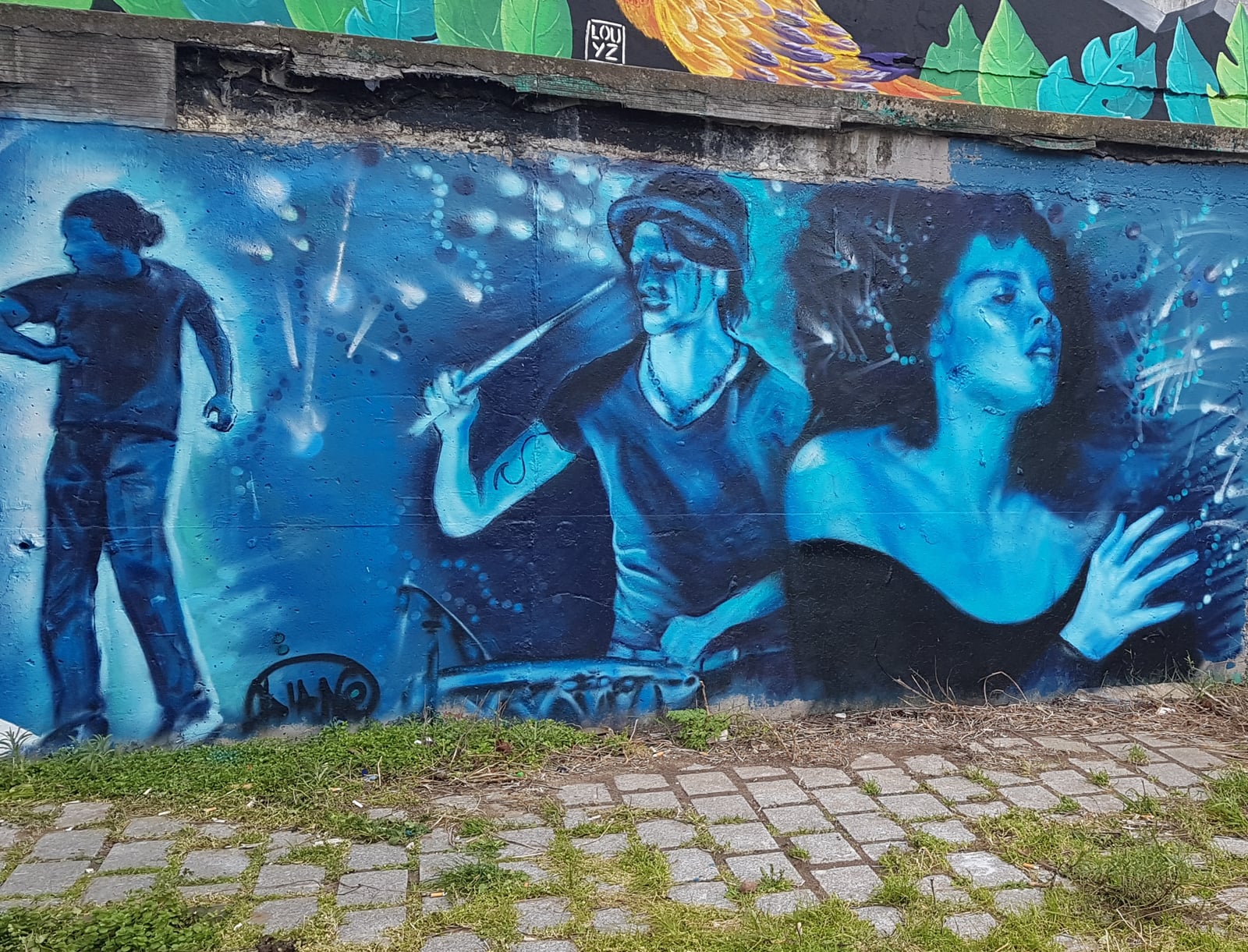 Fresque trois personnages en bleu, scène musicale urbaine