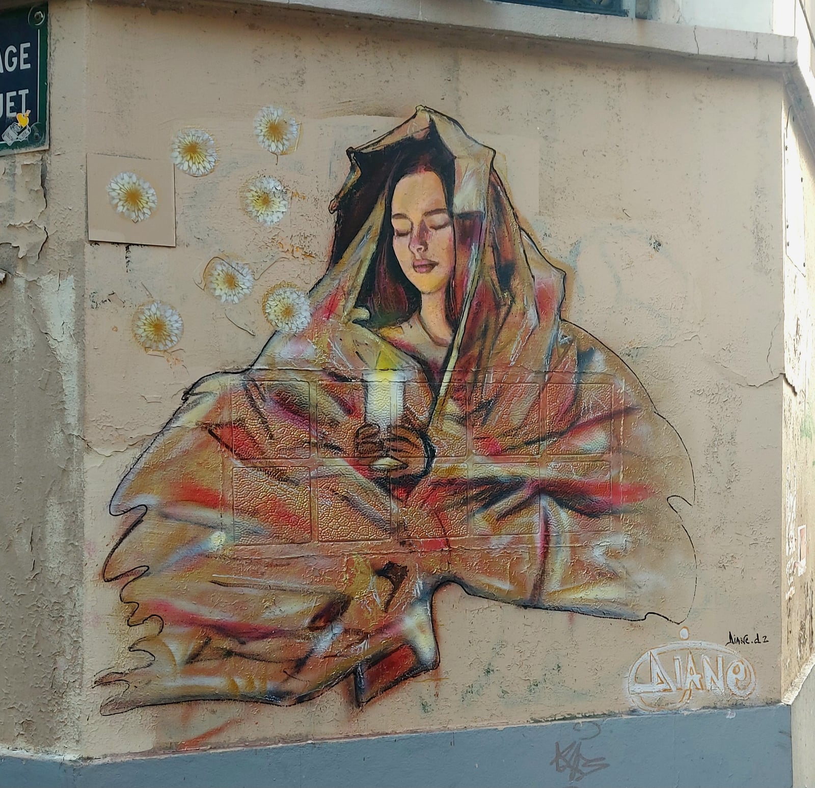 Fresque femme enveloppée dans un voile doré, mur de ville