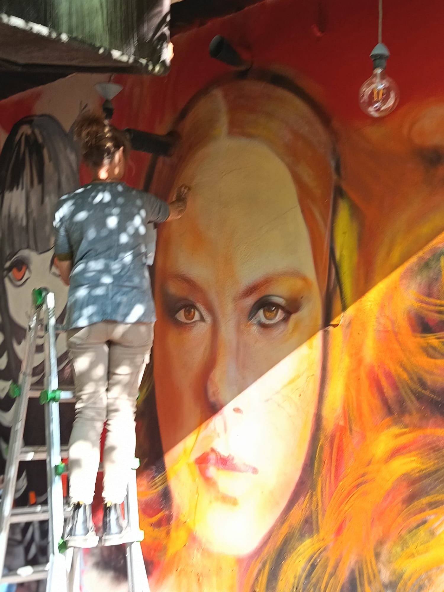Diane sur l’échelle en train de peindre une fresque