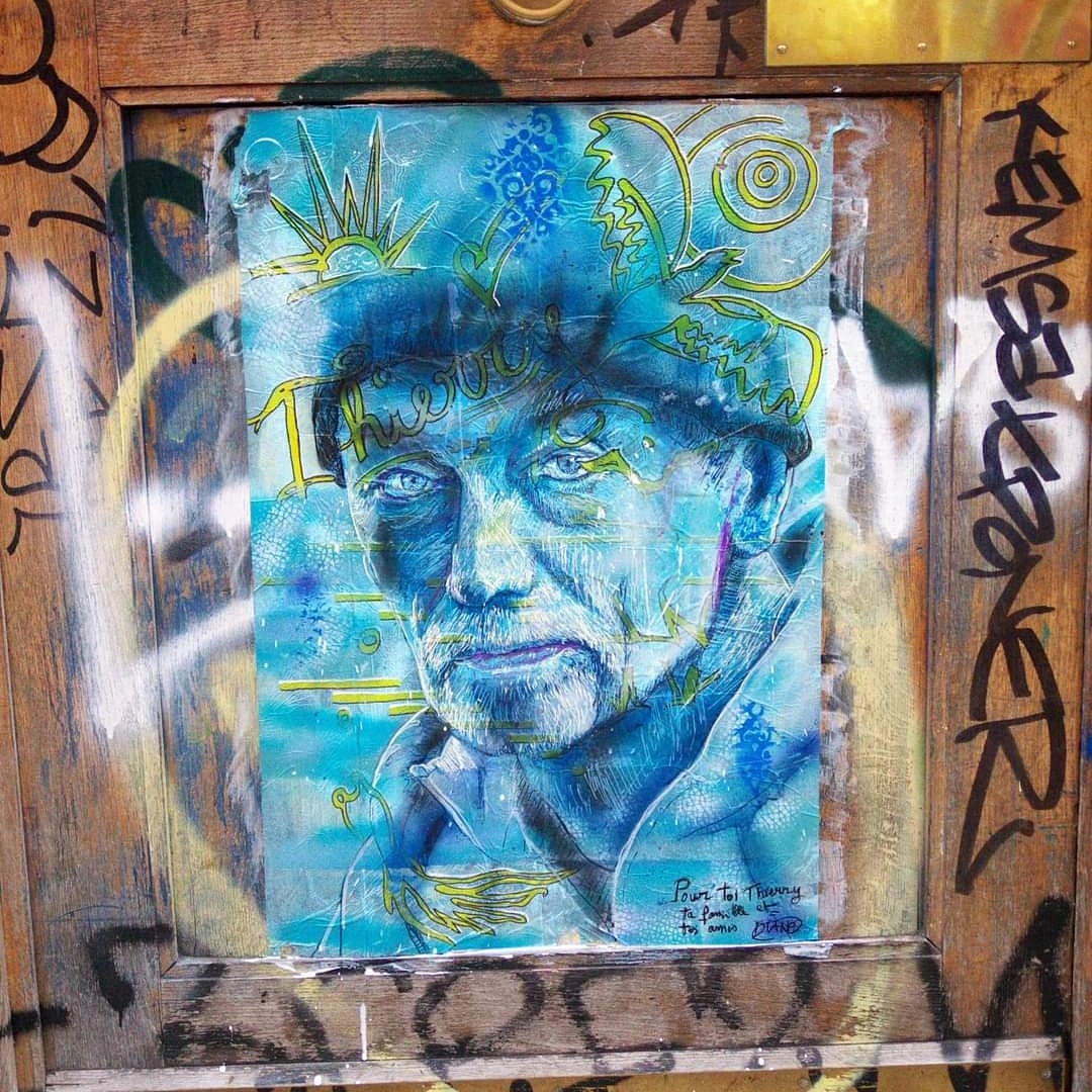 Portrait collé sur porte ornée de graffitis — homme bleu