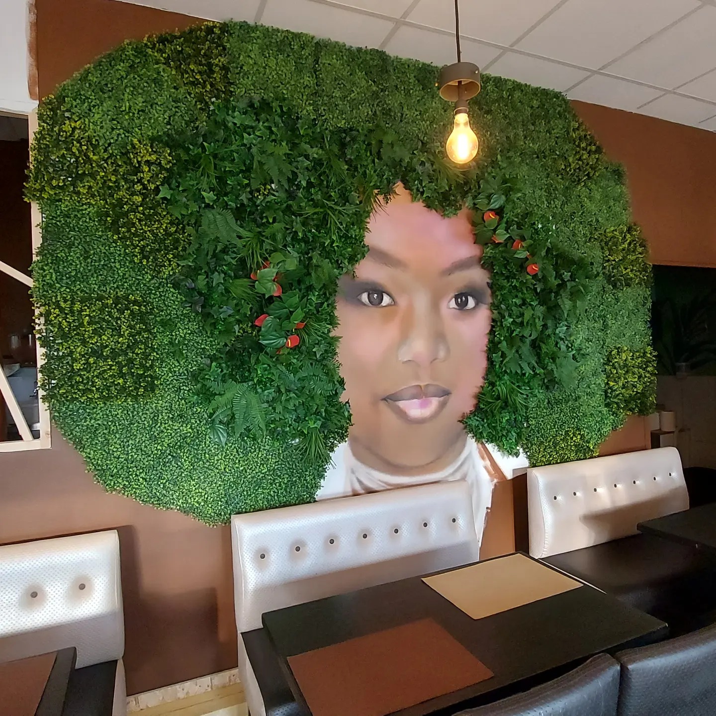 Portrait femme afro intégré dans mur végétal